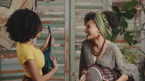 traditional african music. two young african american stylish women playing music on ukulele and djembe