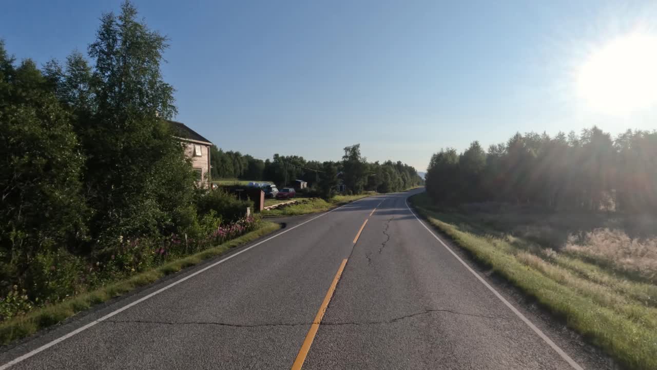 Driving a Car on a Road in Norway at dawn.