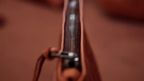 close up of a zipper on a hand made caramel leather bag