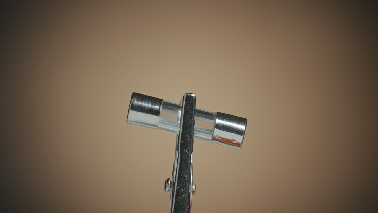 회전 테이블에 있는 전자 부품의 유리 퓨즈와 매크로 샷을 닫습니다.