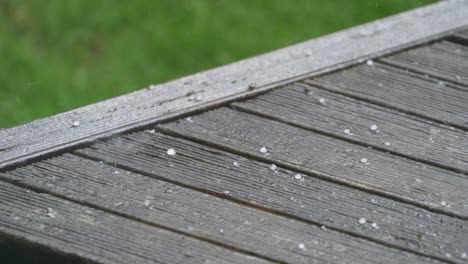 el granizo cae sobre una plataforma de madera en cámara lenta