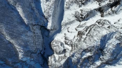 Toma-Giratoria-De-Arriba-Hacia-Abajo-Del-Valle-Del-Monte-Myōkō-En-Japón,-Donde-Se-Revela-La-Enorme-Altura-De-Las-Montañas.