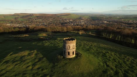 Historic-stone-monument,-rolling-hills-and-Buxton-town-landscape