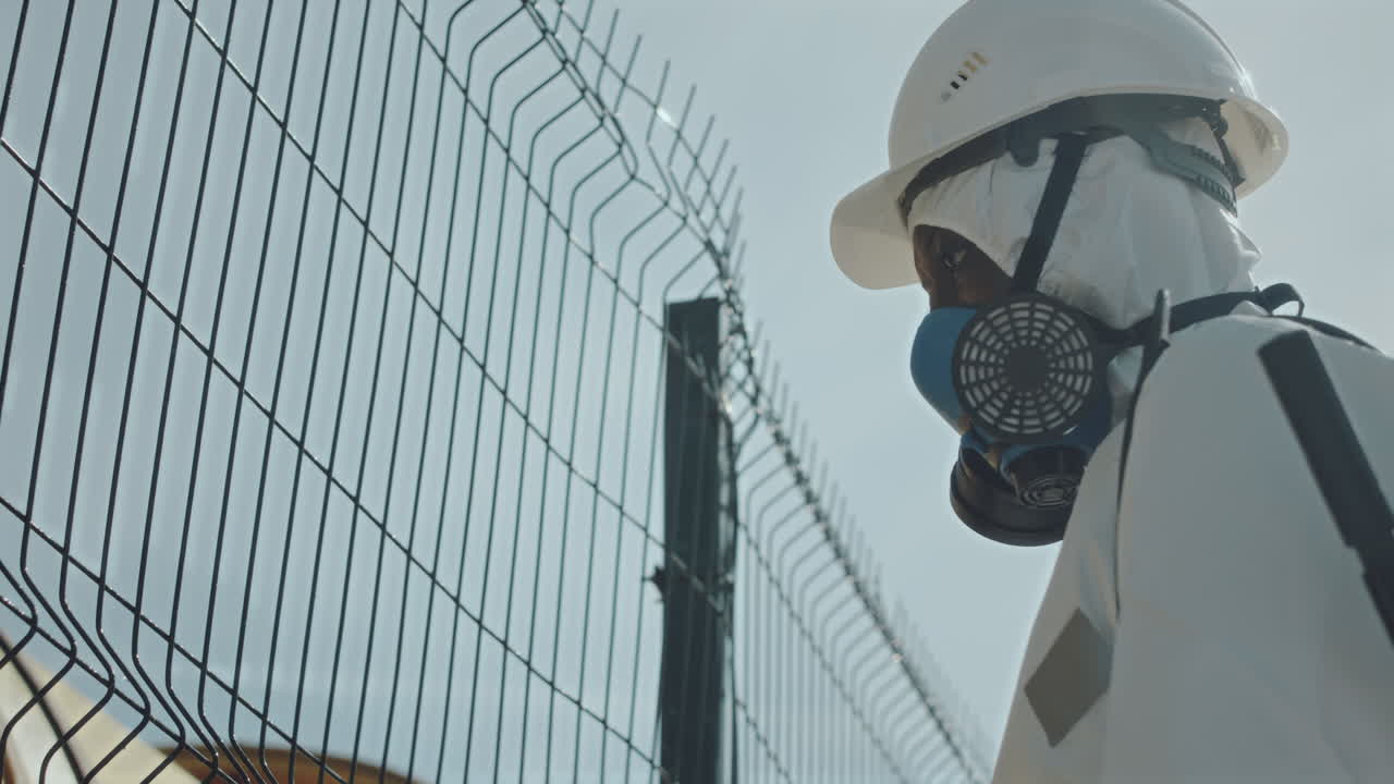 Ecologist in Protective Uniform Using Backpack Sprayer