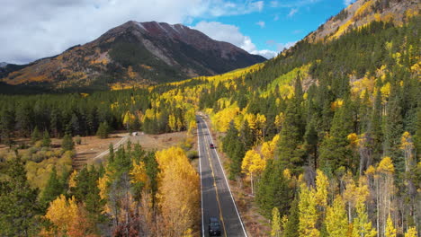 aerial view of traffic on mountain pass and autumn foliage, scenic landscape and road on sunny day