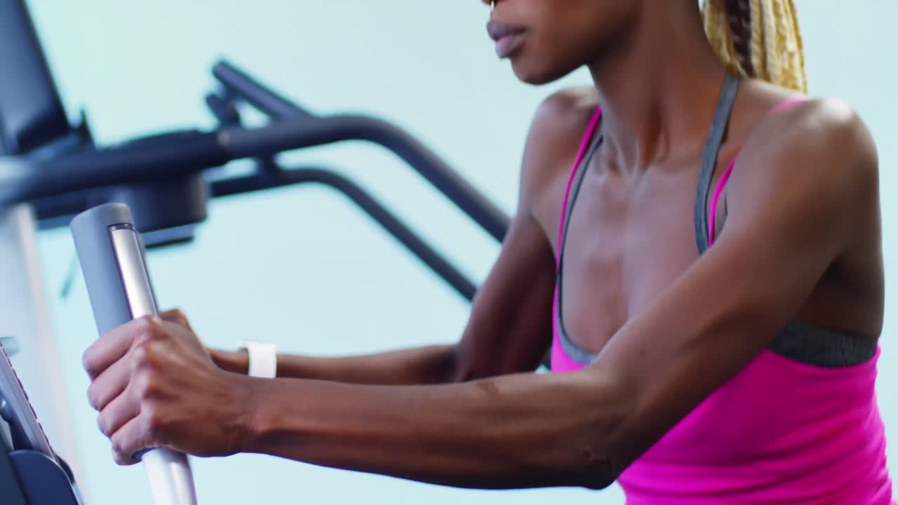 Fit woman exercising on cross trainer