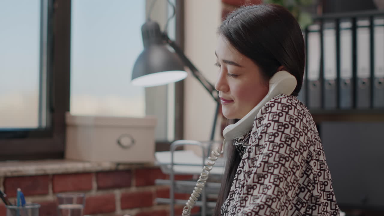 Close up of employee talking on phone call with landline phone