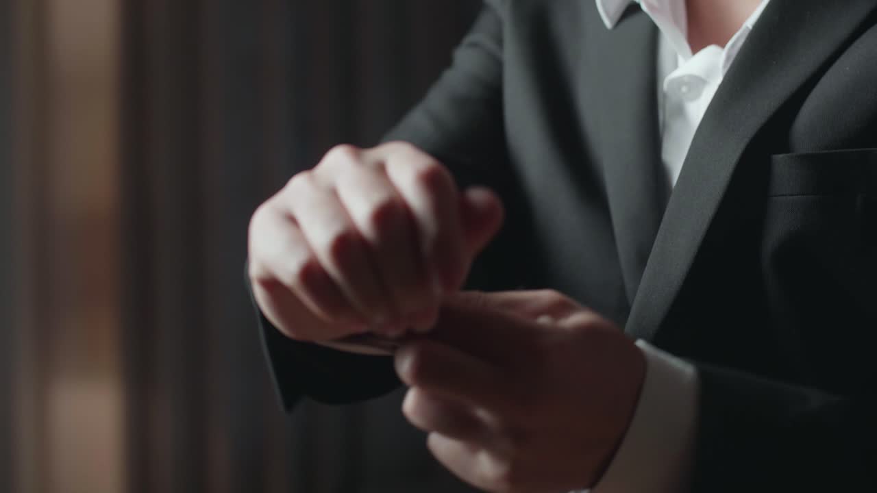 Man buttoning his suit cuffs