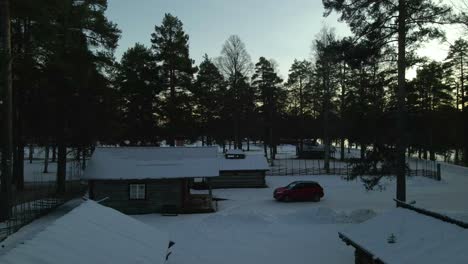 snow covered log cabins in scandinavia, winter vacation concept, aerial