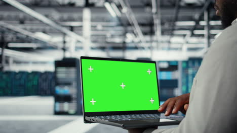 technician upgrading equipment in data center using isolated screen laptop