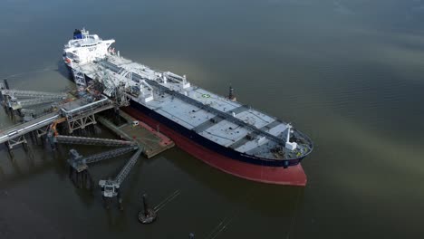 crude oil tanker ship loading at refinery harbour terminal aerial view zoom in to deck