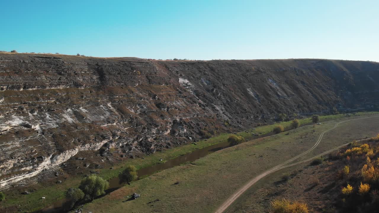 Aerial view of a canyon with a river and a dirt road
