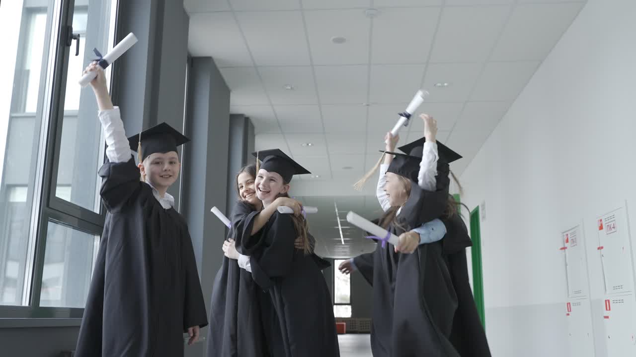 grupo de felices estudiantes de preescolar multirraciales con birrete y bata. están sosteniendo sus diplomas y saltando. ellos son muy felices.