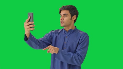 angry indian man shouting on video call green screen