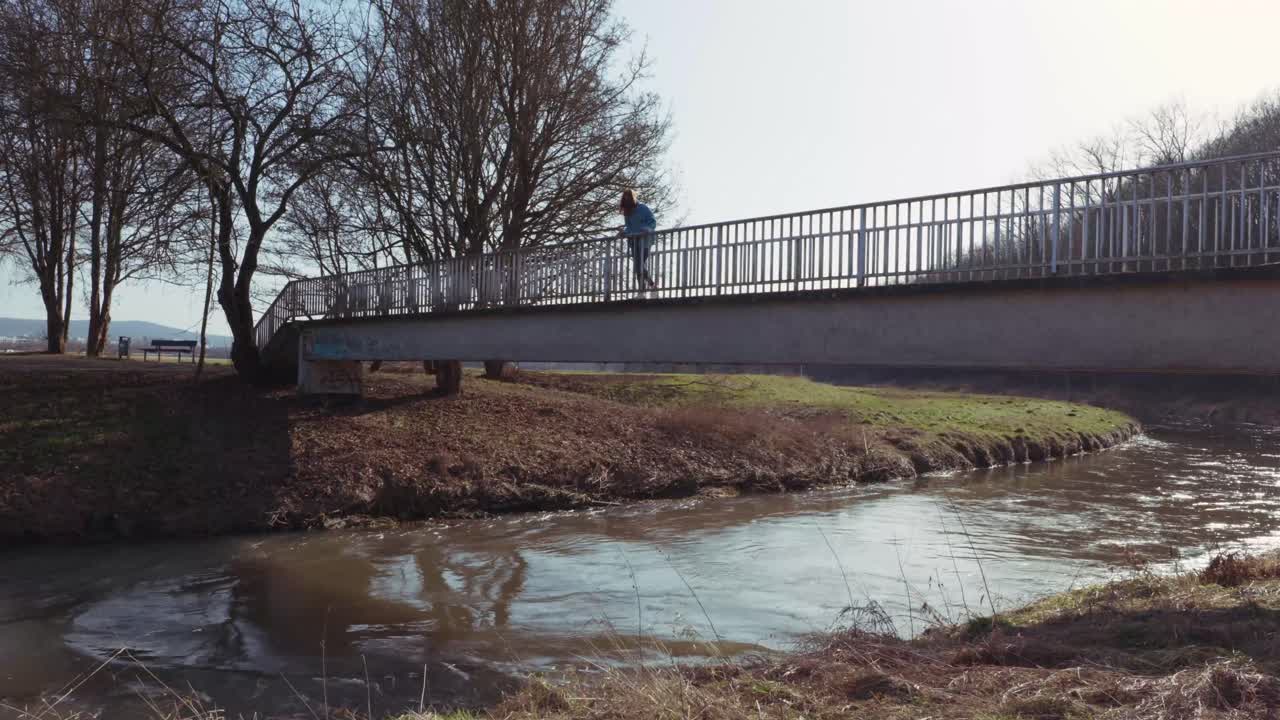 Girl standing alone on a Bridge looking in the Distance