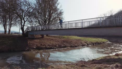 girl standing alone on a bridge looking in the distance