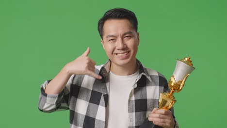 트로피와 전화 제스처를 가진 남자