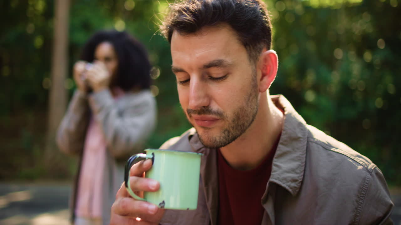Couple enjoying hot drinks in the forest