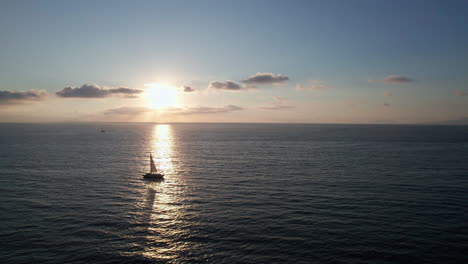 Silhouetted-Sailboat-Orbit:-Sunlit-Contrasts-and-Intense-Shadows---Aerial-Drone-Video