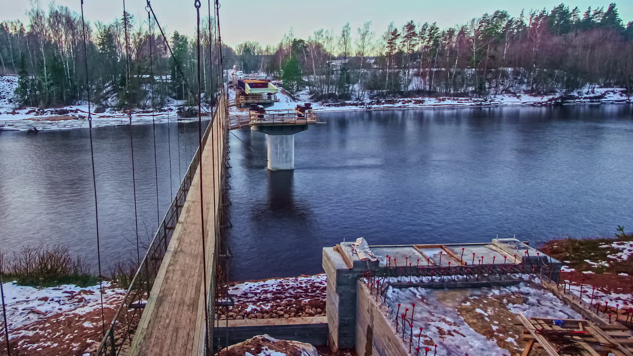 Time lapse of steel beams being installed as the base of a bridge in Latvia's Gauja National Park