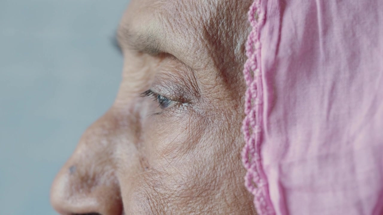 Close-up Profile of Elderly Woman Wearing a Pink Headscarf