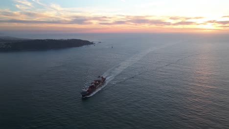 aerial view around a bulk carrier on the coast of san francisco, during sunset - circling, drone shot