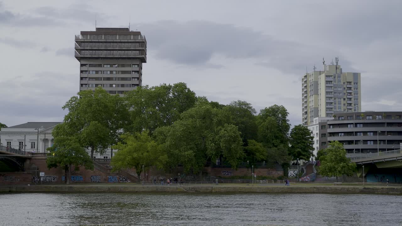 Urban landscape with trees, buildings, and river in Frankfurt, Germany