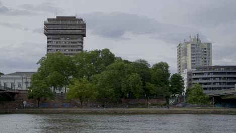 urban landscape with trees, buildings, and river in frankfurt, germany
