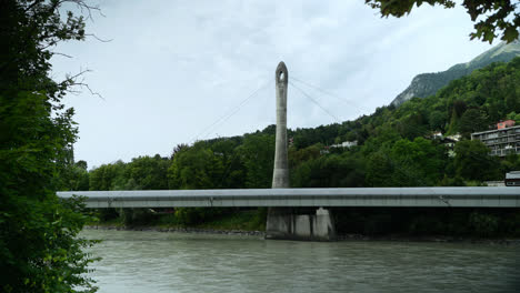 handheld shot of the river the inn flowing under the neue hungerburgbahn bridge in innsbruck, austria