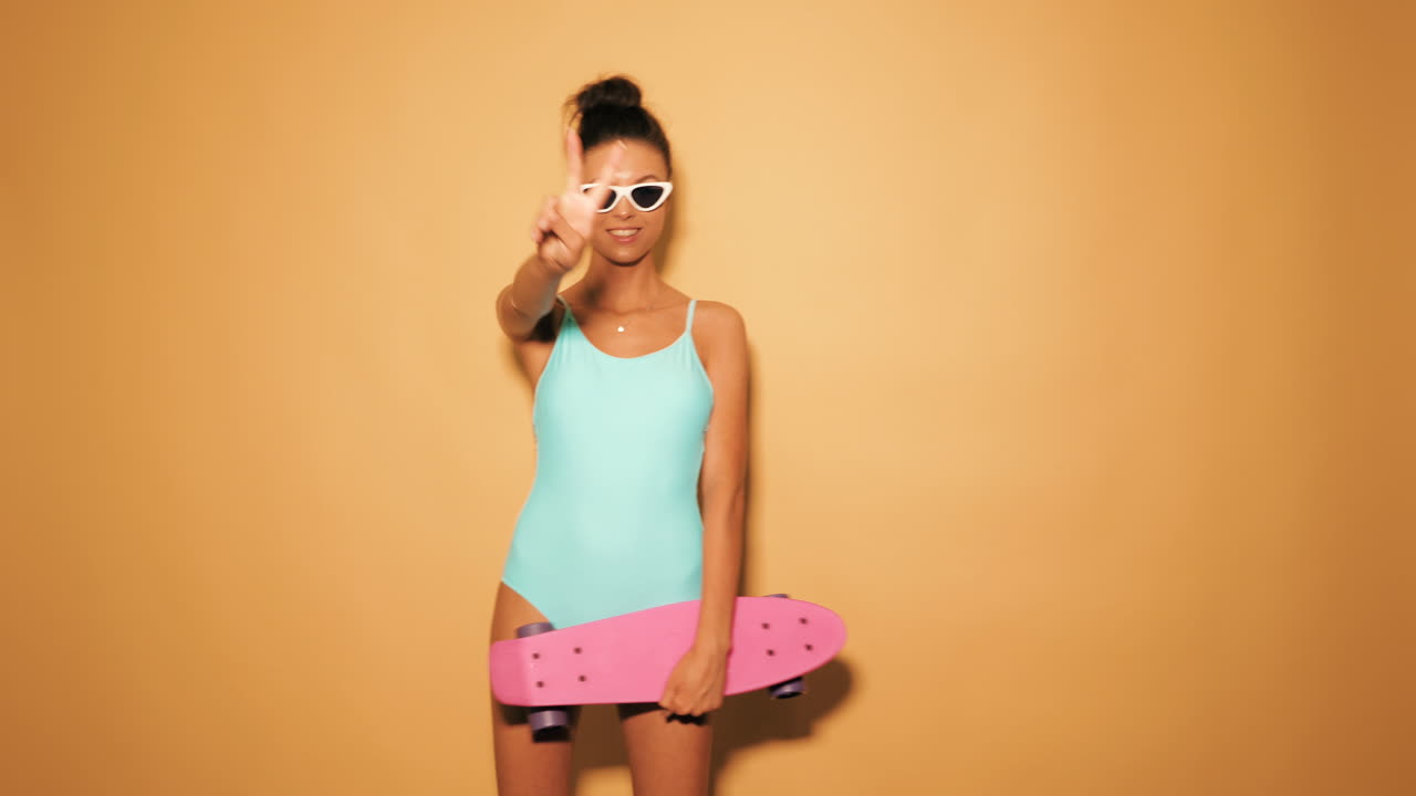 mujer en traje de baño con una patineta