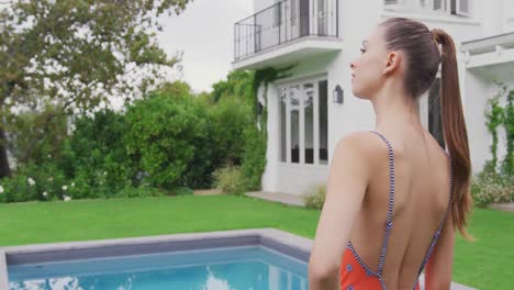 woman in swimwear standing with hands on hip near swimming pool 4k