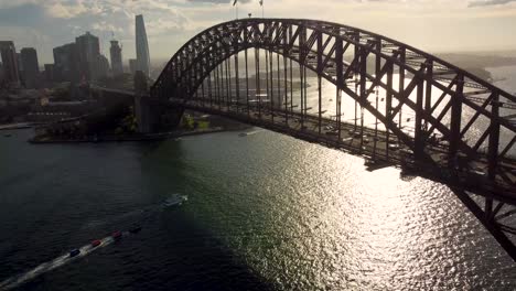 drone aerial shot of iconic sydney harbour bridge with cars commute tourism landmark cityscape in late afternoon nsw australia 4k