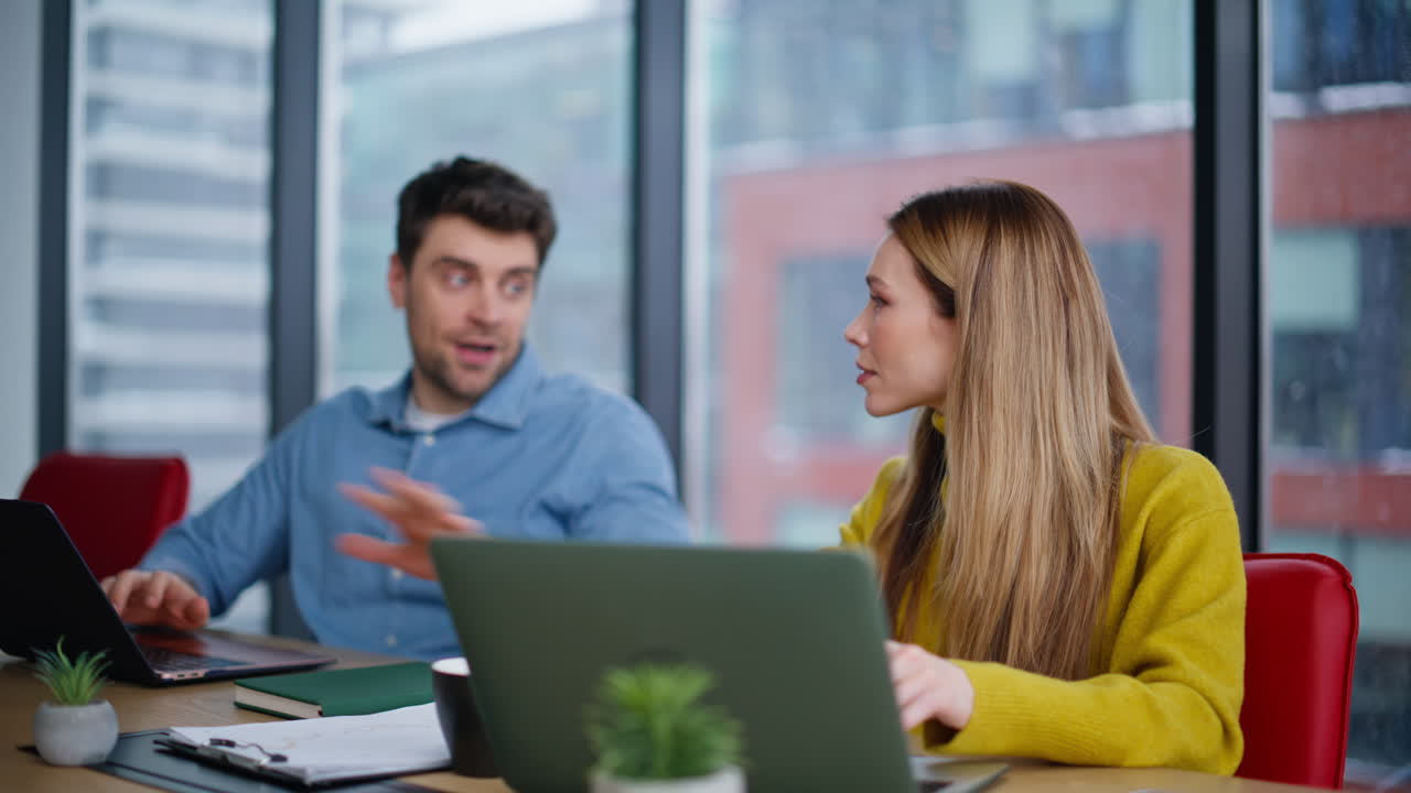 Two colleagues consulting project in modern office closeup. Positive woman man