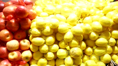 vibrant apples and lemons stacked in a supermarket, showcasing bright colors and fresh produce under warm lighting