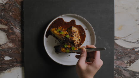 overhead shot of a chef plating a gourmet sweet potato dish in a restaurant