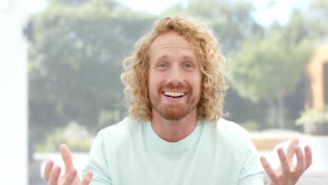 happy caucasian man making video call, talking and waving at home, slow motion