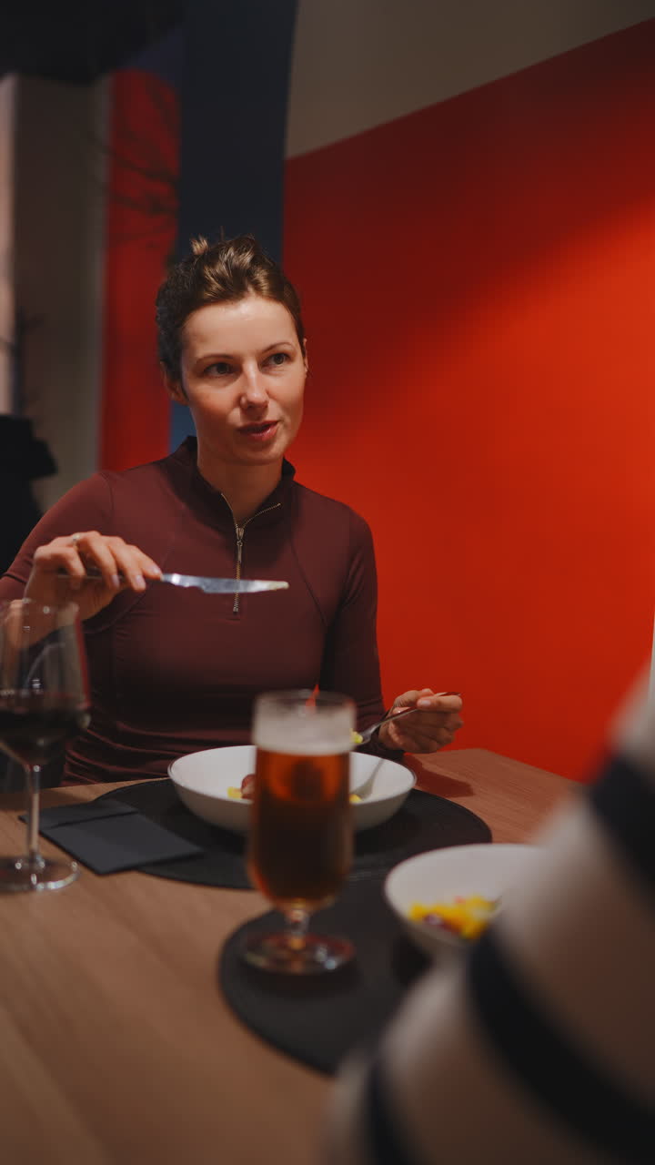 Woman Enjoying a Meal and Conversation in a Restaurant