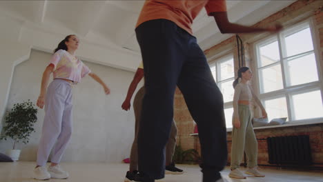 young people dancing with teacher in studio