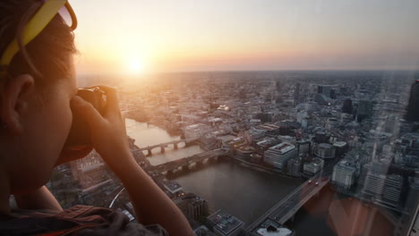 tourist taking photograph of sunset in london skyline  view from the shard