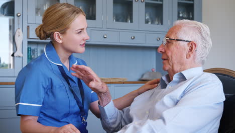 female community nurse visiting senior man at home