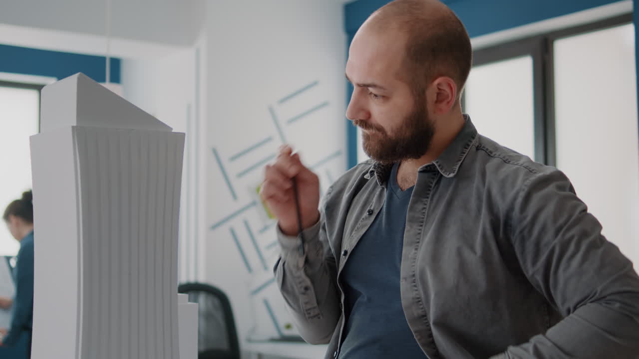 Man working on a building model in an office