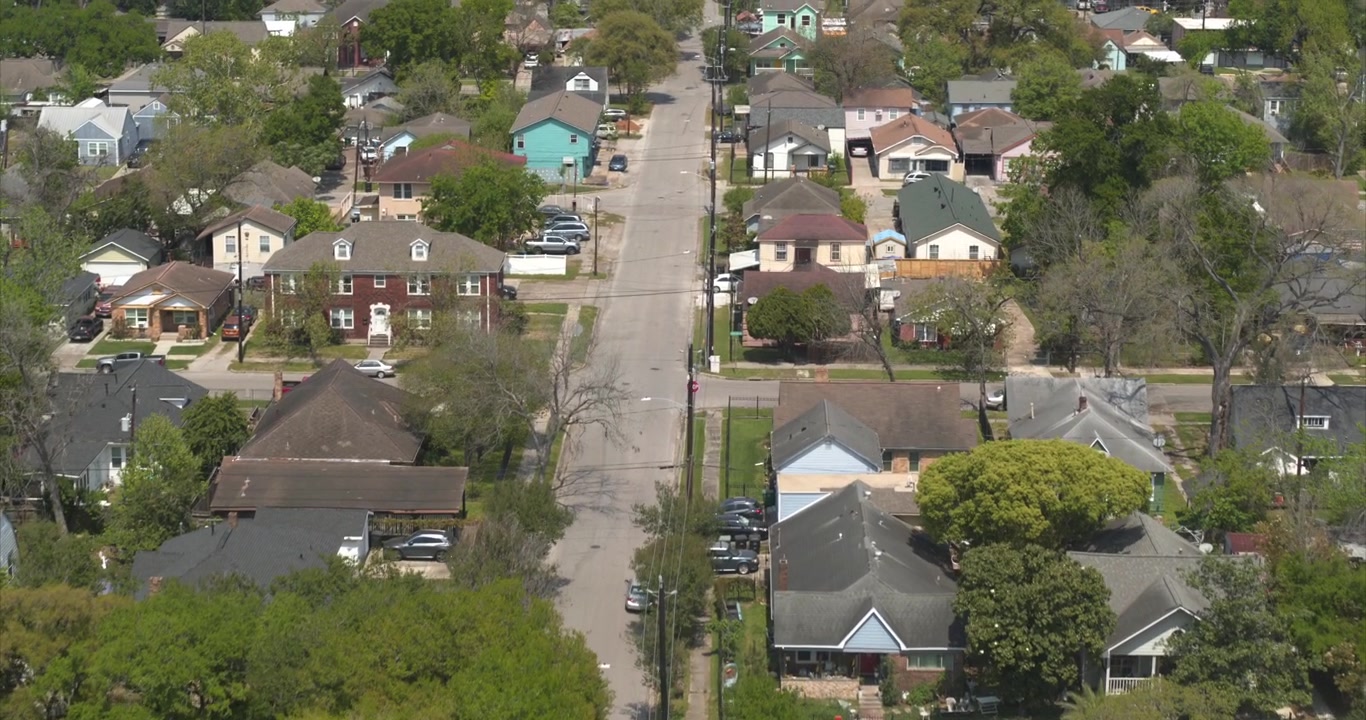 Questa veduta aerea con drone cattura le case residenziali nella zona nord-est di Houston, Texas, mostrando un tipico quartiere suburbano con case unifamiliari, strade alberate e spazi verdi