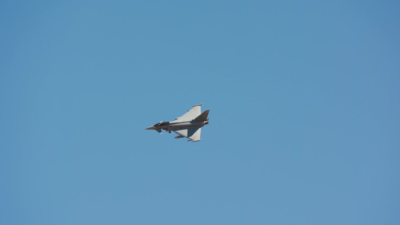 Fighter jet flying in clear blue sky with gear down