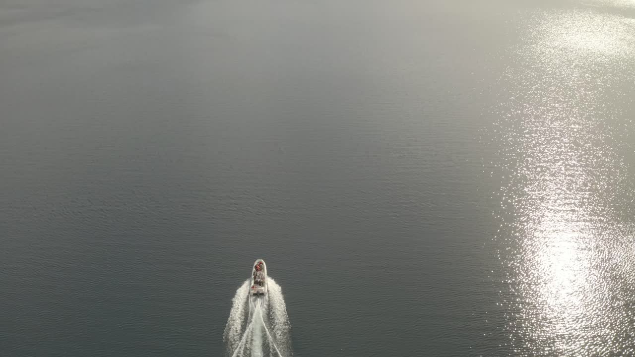 Slow motion aerial shot of a boat navigating in Lacar lake and revealing the landscape