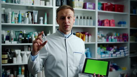 farmacéutico masculino sosteniendo una tableta digital con una pantalla verde en un farmacéutico, recomienda su uso. retrato masculino