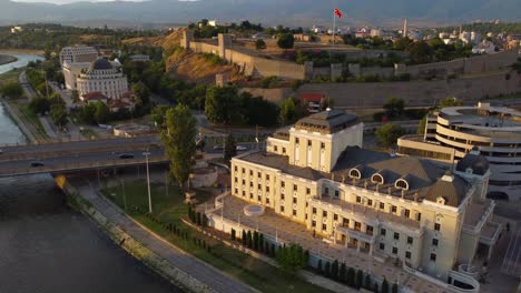 skopje drone video over vardar river with national theatre and kale fortress with macedonian flag - skopje, macedonia