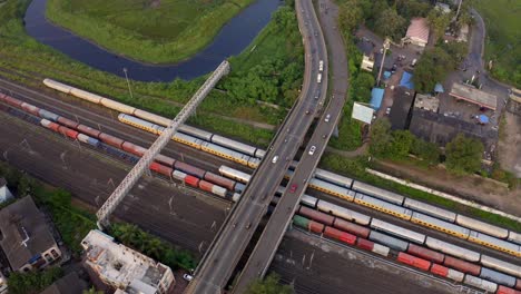 Vista-Aérea-De-Coloridos-Trenes-De-Carga-En-La-Estación-De-Tren-En-Vasai,-India---Disparo-De-Drones