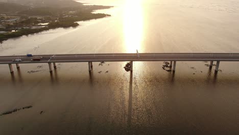 Traffic-on-Hong-Kong-Shenzhen-Bay-Bridge-at-Sunset,-with-Fish-and-Oyster-cultivation-pools,-Aerial-view