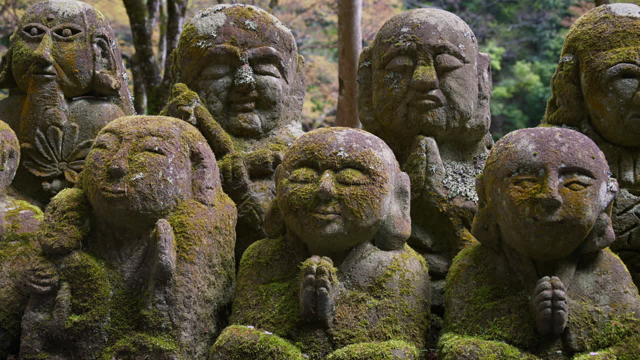Moss-covered arhat statues covering the hillside around the temple grounds at the Otagi Nenbutsuji Temple in Kyoto, Japan
