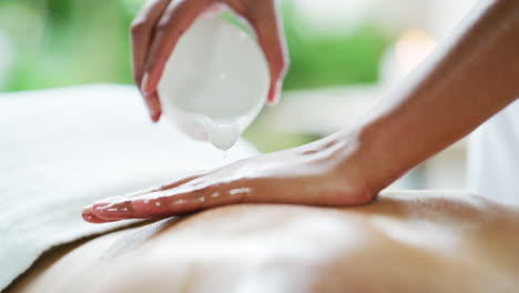 a massage therapist using body oil while giving